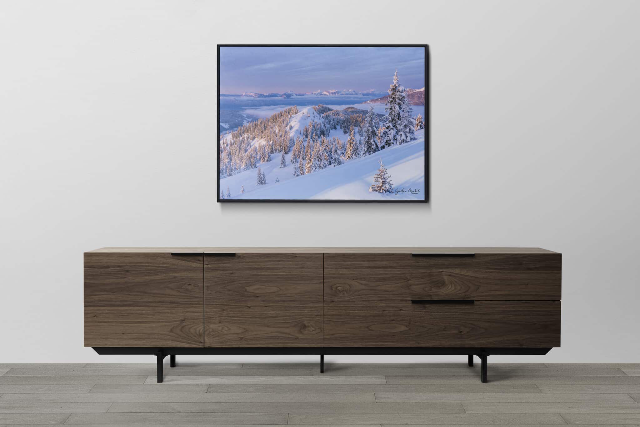 Paysage hivernal depuis le massif de Belledonne avec vue sur les Bauges, sapins enneigés et mer de nuages baignés par la lumière de fin de journée.