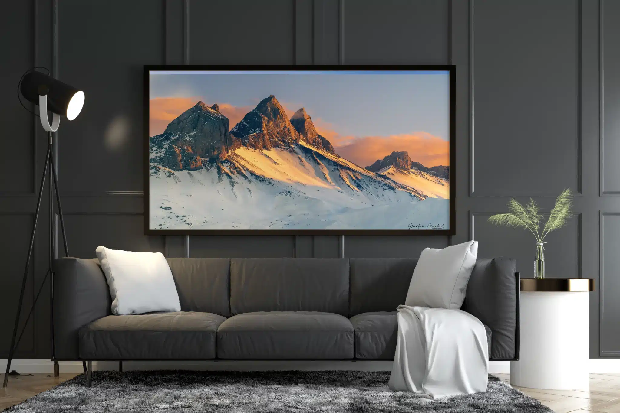 Mockup d'un tirage encadré des Aiguilles d’Arves au coucher de soleil, exposé dans un salon moderne avec canapé gris et décoration contemporaine, par Gaëtan Michel