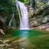 Cascade en écume dans le torrent de l’Alloix en Chartreuse, avec une eau turquoise s’écoulant entre des rochers moussus, entourée d’une forêt alpine dense.Photo prise par gaëtan Michel
