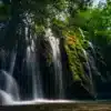 Cascade d’Aubres dans les Baronnies, avec une eau cristalline dévalant des rochers couverts de mousse verte. La lumière naturelle filtre à travers les arbres, créant des jeux d’ombre et de lumière sur l’eau et la végétation dense des Baronnies.