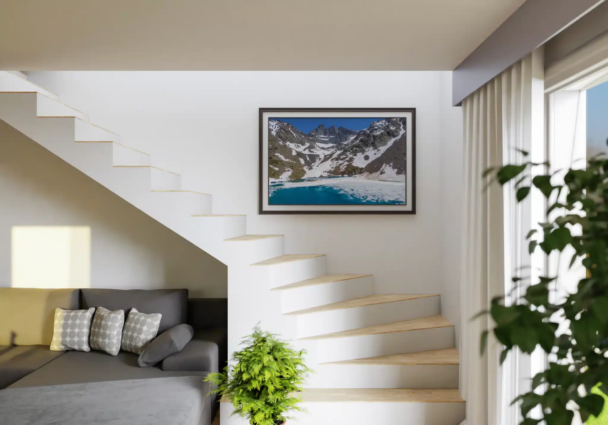 Visualisation du tirage photo du Lac Blanc de Belledonne dans un intérieur lumineux. Photographie encadrée du Lac Blanc de Belledonne en débâcle présentée sur un mur blanc à côté d’un escalier moderne.