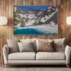 Tableau photo du Lac Blanc de Belledonne en débâcle accroché au-dessus d’un canapé dans un salon chaleureux.