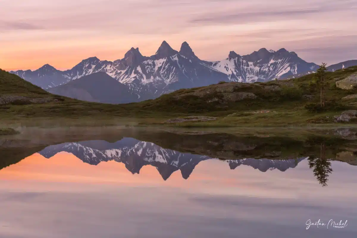 Reflet des Aiguilles d’Arves dans le lac Potron au Col de la Croix de Fer, au lever du jour.