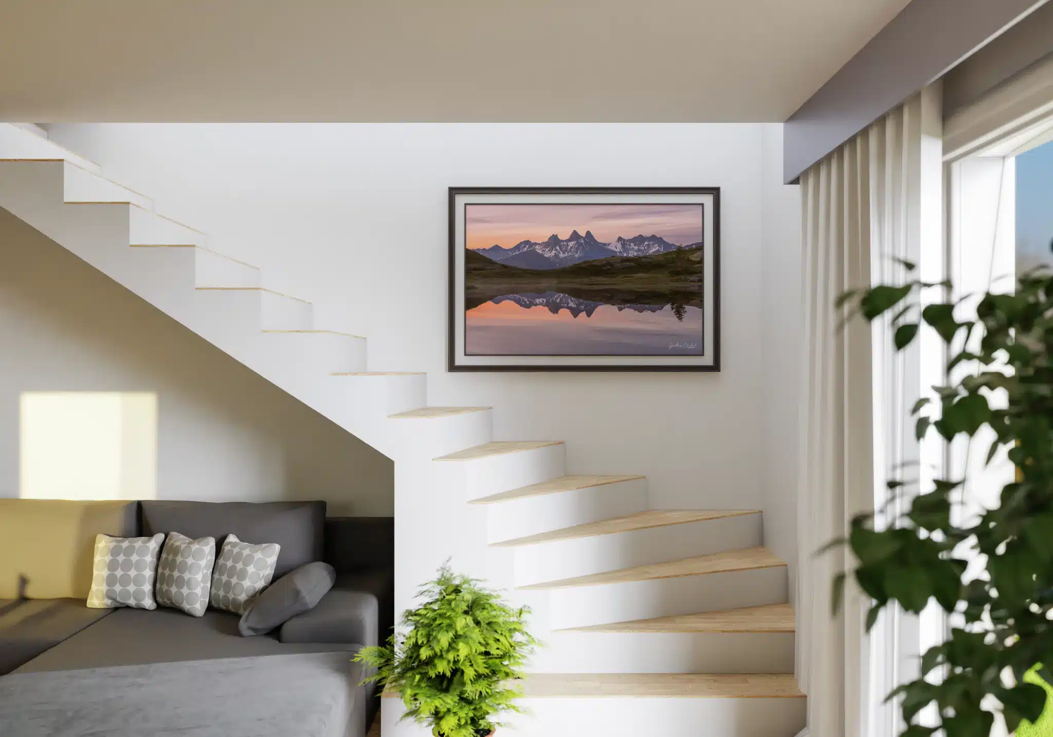 Visualisation du tirage photo des Aiguilles d’Arves dans un intérieur lumineux et contemporain. Photographie encadrée des Aiguilles d’Arves au lever du jour accrochée sur un mur blanc à côté d’un escalier moderne.