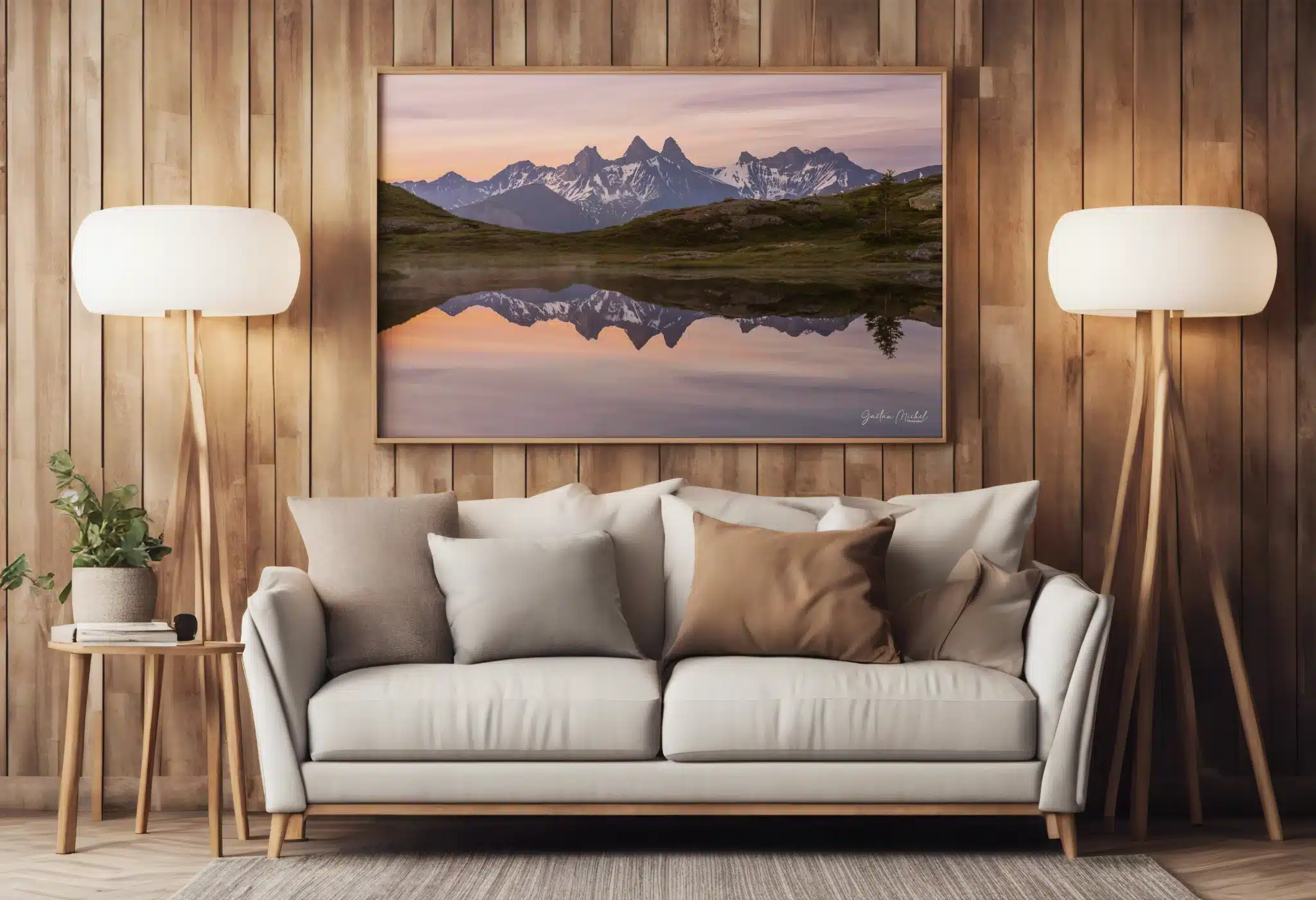 Mise en situation du tirage photo des Aiguilles d’Arves dans un salon contemporain. Tirage photo encadré des Aiguilles d’Arves se reflétant dans un lac au lever du jour, présenté au-dessus d’un canapé dans un salon chaleureux.