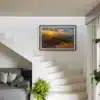 Tirage d’art d’un coucher de soleil sur le lac de Roselend présenté dans un intérieur moderne au-dessus d’un escalier.